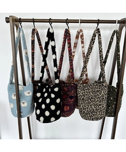Variety of plush leopard print and patterned faux fur bucket bags hanging on a rack