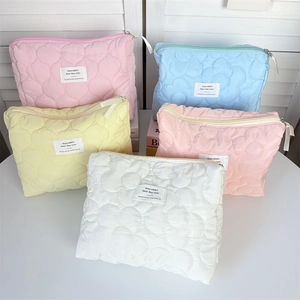 Multiple colorful quilted floral cosmetic bags showing soft textures and zipper detail