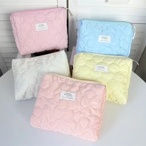 Detailed close-up of quilted floral pattern cosmetic bags in five pastel colors