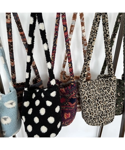 Collection of plush bucket bags with various animal prints and patterns on a soft faux fur fabric
