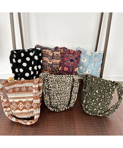 Selection of plush animal print and geometric pattern bucket bags on wooden floor