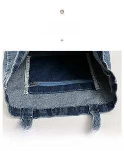 Close-up of internal blue zipper pocket and stitching on washed denim tote bag