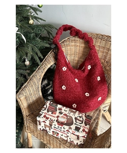 Detail der roten Plüsch-Hobo-Tasche mit Blumen-Patches und gerafftem Riemen in Festdeko
