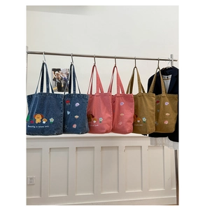Detailed display of denim tote bags with cute puppy embroidery in three color options