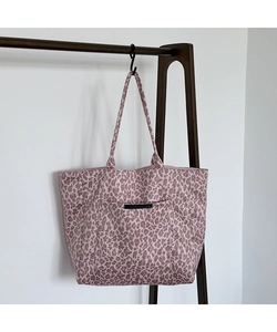 Detail view of pink leopard print tote bag with large front pocket and woven label
