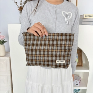 Detailed view of vintage plaid canvas makeup bag with premium woven label and durable texture