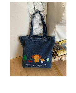Detailed close-up of rainbow dog embroidery on a vintage dark blue denim tote bag