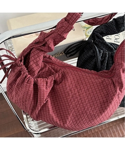 Detail of burgundy checkered crescent bag with drawstring pleated shoulder strap