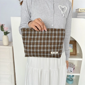 Large checkered canvas pouch with zipper and MAY RABBIT label held by a model