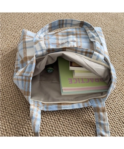 Detailed interior of plaid tote bag showing gray lining, inner pocket and large capacity