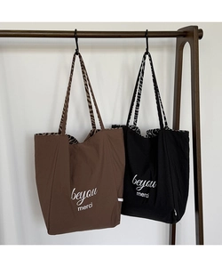 Detail of minimalist tote bags with animal print lining and beyou merci typography
