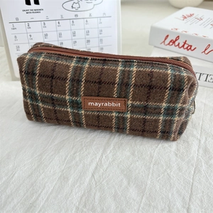 Close-up of vintage brown plaid wool pencil case with premium leather logo and soft zipper