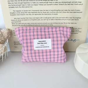Détail de la trousse cosmétique à carreaux rose et bleu avec petite étiquette tissée