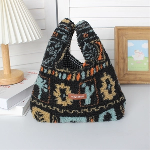 Detail of plush tote bag with ethnic patterns and leather label on a white surface
