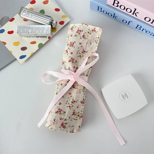 Floral cotton makeup brush wrap roll with pink ribbon bow detail on soft beige fabric