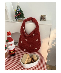 Detail der roten Plüsch-Hobo-Tasche mit weißen Blumen auf Weihnachtskaro-Stoff