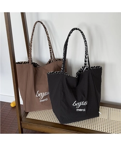 Detail view of stylish brown and black tote bags with leopard lining and merci print