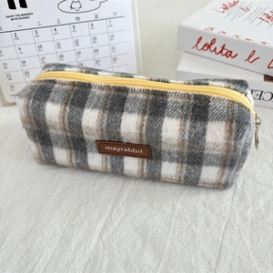 Detail view of vintage plaid wool pencil case with textured fabric and yellow zipper