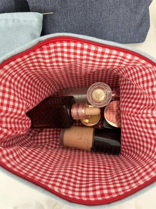Vue détaillée de la trousse en denim avec doublure vichy rouge et fermeture éclair en métal