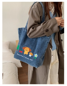 Close-up of blue denim tote bag with cute cartoon dog embroidery and park text