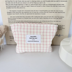 Détail d'une trousse de maquillage à carreaux roses avec fermeture éclair en métal