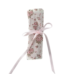 Floral makeup brush roll-up bag with pink rose patterns and a satin ribbon bow tie