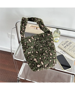 Detailed close-up of dark green leopard print plush fabric texture on a soft tote bag