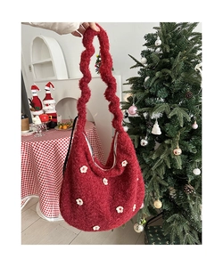 Detail der roten Plüschtasche mit 3D-Blumenakzenten und gewelltem Schultergurt