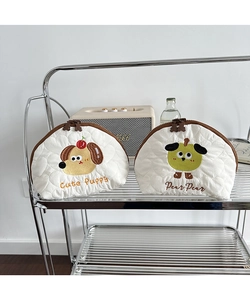 Detail view of heart-quilted cosmetic bags with dog and pear embroidery on metal shelf