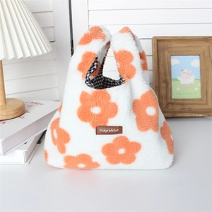 Detail of soft white plush handbag featuring orange flower patterns and plaid fabric lining