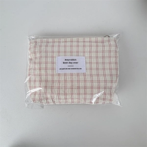 Vue détaillée de la trousse de maquillage à carreaux roses sous emballage plastique