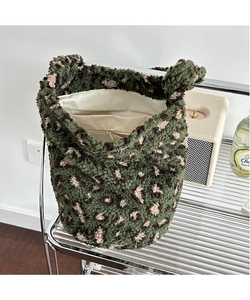 Detail of green leopard plush tote bag with magnetic closure and inner lining pocket