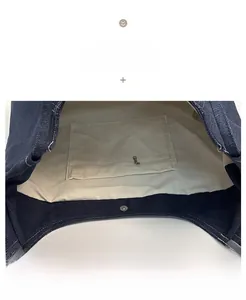Detail of denim tote bag showing canvas lining, interior zipper pocket and magnetic closure