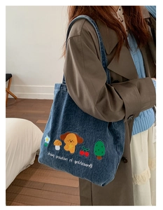 Close-up of vintage denim tote bag with colorful dog and cherry embroidery details