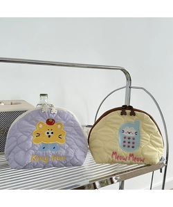 Detail of quilted cotton cosmetic bags with lion and cat embroidery on metal stand