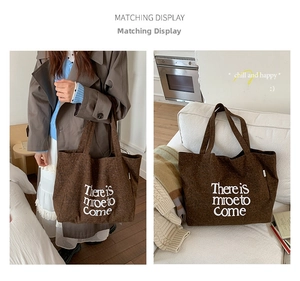 Detail of coffee brown canvas tote bag featuring white letter print and large capacity