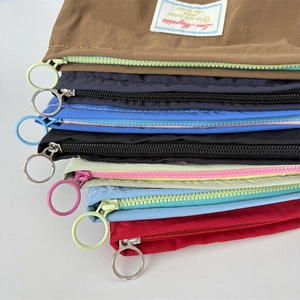 Multiple colorful mini nylon cosmetic bags with contrast zippers and metal ring pulls