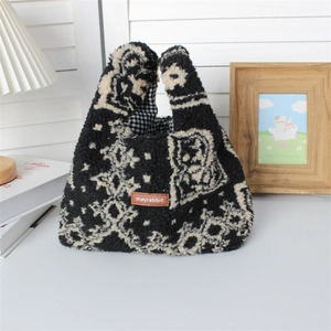 Close-up of fluffy black and white paisley pattern plush tote bag with leather logo tag