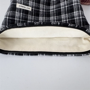 Close-up of black and white checkered canvas storage bag with durable zipper and lining