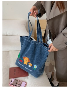 Close-up of embroidered puppy and nature park text on washed denim tote bag