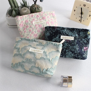 Detailed view of jacquard floral canvas makeup pouches with zipper and woven labels