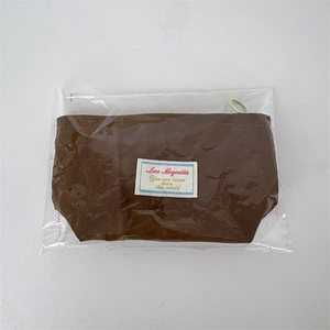 Brown fabric makeup pouch featuring a rectangular logo patch and green zipper pull loop