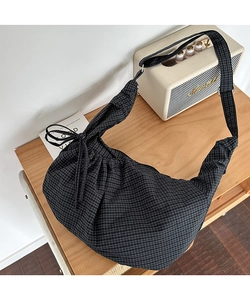 Detail view of crescent canvas bag with black and white gingham pattern and drawstring bow