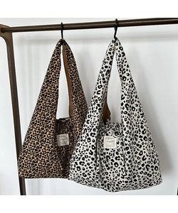 Detail of leopard print corduroy tote bags in brown and beige with magazine patch