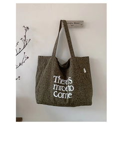 Detail of leopard print canvas tote bag featuring white handwritten slogan embroidery