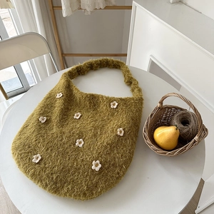 Detailaufnahme der moosgrünen Plüschtasche mit weißen 3D-gestrickten Blumenmotiven