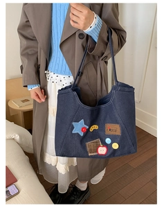 Detail of vintage denim tote bag with colorful patches, stars and embroidery stitching