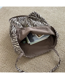 Spacious interior of zebra print plush tote bag showing capacity for magazines