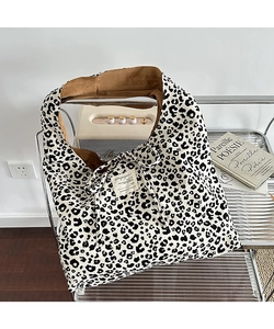 Macro detail of leopard print tote bag with corduroy texture and decorative lace-up closure
