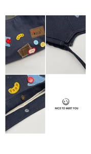 Detail of denim tote bag showing colorful buttons, patchwork embroidery and metal snap buttons